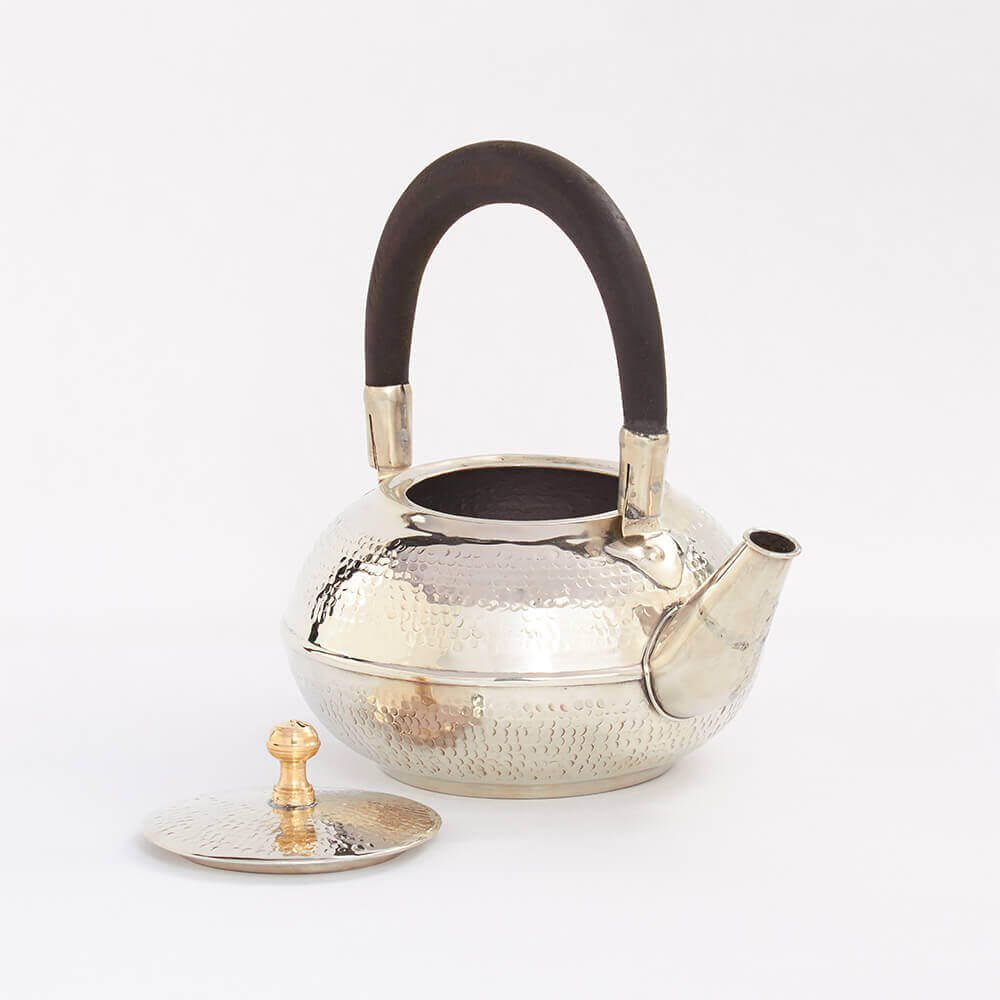 Moroccan silver hammered teapot with open lid.