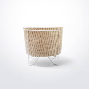 Palm leaf basket with white stand small gray background.