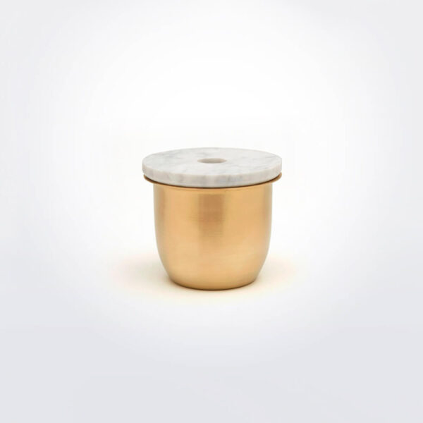 Brass metal and marble container gray background.